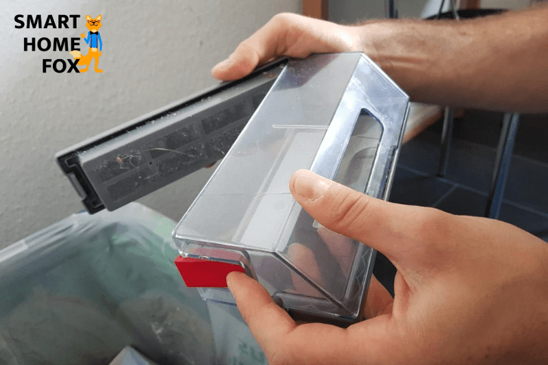 Mobiler Staubbeutel wird per Hand über dem Mülleimer ausgeleert.